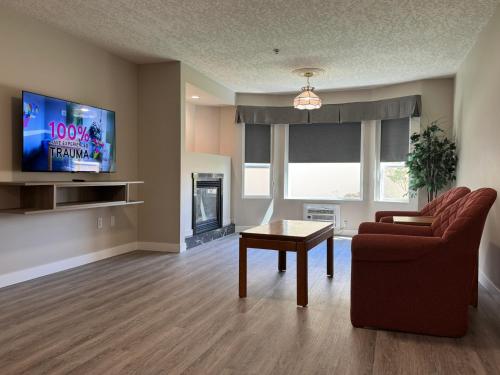 a living room with a couch and a table and a tv at Western Budget Motel Leduc #3 in Leduc