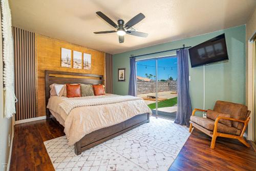 ユマにあるRiver Fun Awaits Pool, Putting Green, Arcade and More, Sleeps 8のベッドルーム1室(ベッド1台、ファン、椅子付)