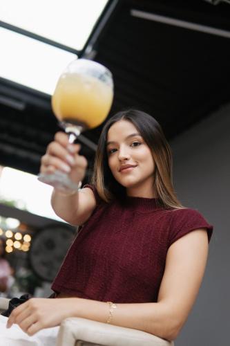 a woman is holding a glass of orange juice at Qantic Lodging & Rooftop in Medellín