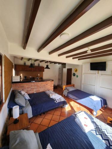 a room with two beds and a television in it at Hotel Ficus Villa de Leyva in Villa de Leyva