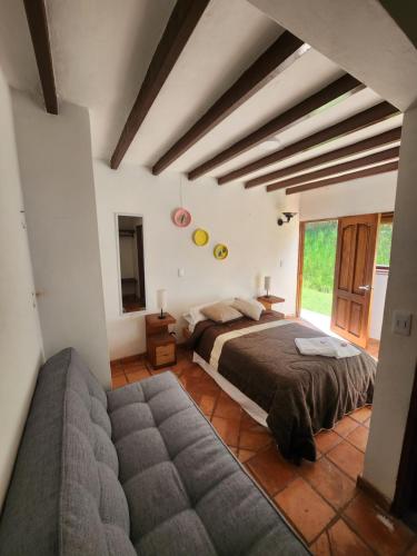 a large bedroom with a bed and a couch at Hotel Ficus Villa de Leyva in Villa de Leyva