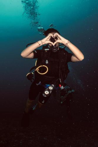 a person with a camera in the water at Rising Sun Bungalows in Gili Meno