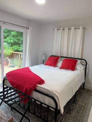 a bedroom with a bed with red pillows and a window at Belle Cottage in Eagle Rock