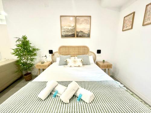 une chambre avec un grand lit avec deux oreillers dans l'établissement Designer studio 5 min from train Station María Zambrano and 15 min from beach, à Malaga