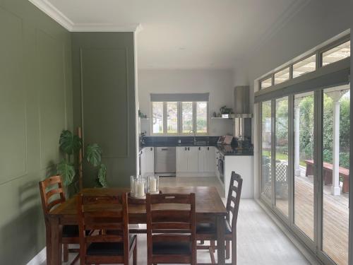 a dining room with a wooden table and chairs at Picture Perfect in the heart of the Village in Greytown