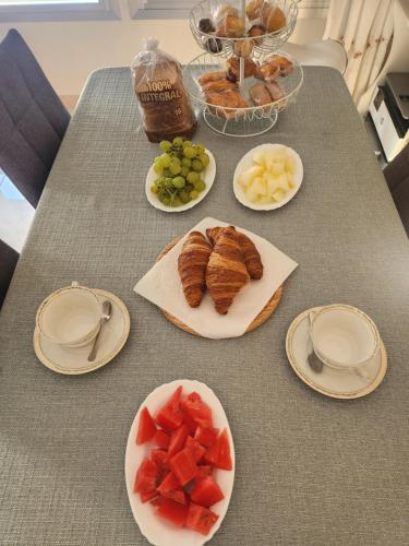 una mesa con platos de comida y fruta. en Room Lidón Center 2, en Castellón de la Plana