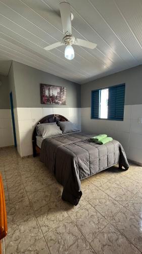 een slaapkamer met een bed en een plafondventilator bij Ótima suíte privativa no Centro Histórico in Goiás