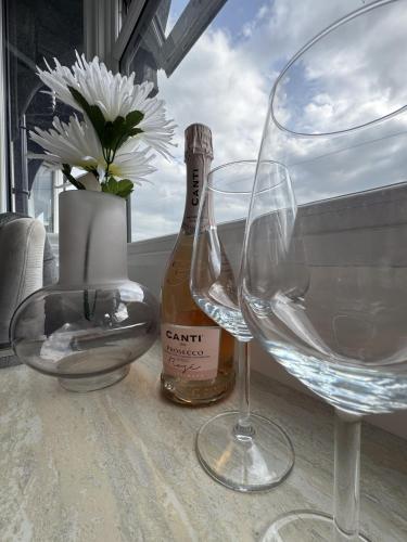 a table with two wine glasses and a bottle of wine at Stunning 1 BR Studio - NEC, BHX, HS2, JLR - Free Netflix in Marston Green