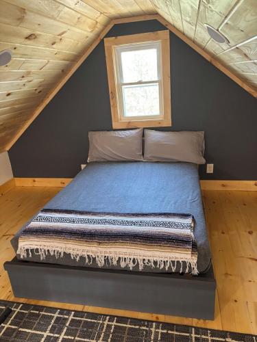 a bed in a room with a window at Camptown Cabin in Eagle Rock