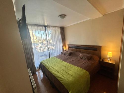 a bedroom with a bed and a large window at EcoApart Concepción in Concepción