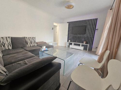 a living room with a couch and a glass table at Comfy Apartment Near Shops & Station in Slough