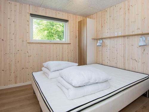 a bedroom with a bed with white pillows at 16 person holiday home in Glesborg in Glesborg