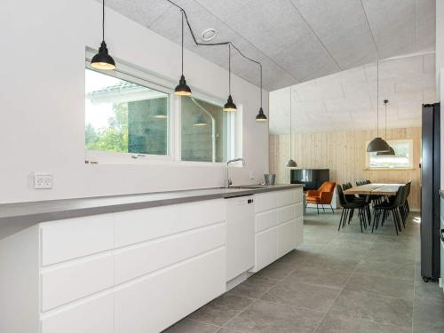 a kitchen with white cabinets and a dining room at 16 person holiday home in Glesborg in Glesborg