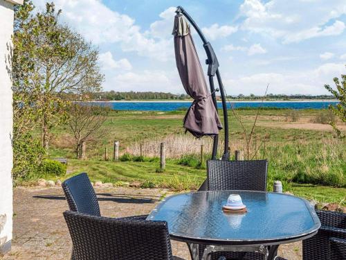 ÅrøsundにあるLuxury Seaside Retreat - By Traum Ferienwohnungenのテーブルと椅子、パラソルと飲料水