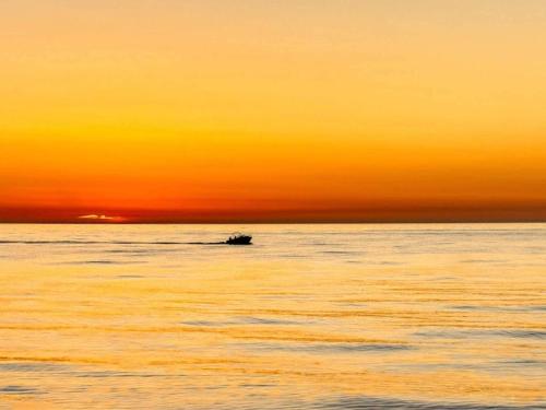 a boat in the ocean at sunset at 6 person holiday home in Kolind-By Traum in Kolind
