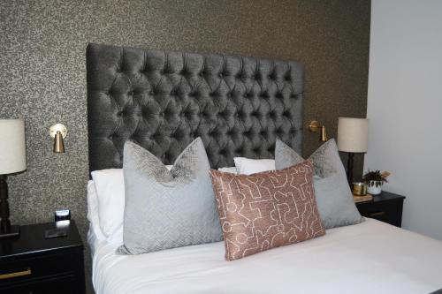 a bedroom with a bed with a black headboard and pillows at Luxury Croft Templepatrick Near Airport Rabbit and Hilton hotel in Templepatrick