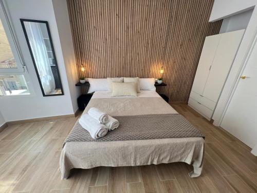 a bedroom with a large bed with towels on it at Thor Hostal Boutique in Alicante