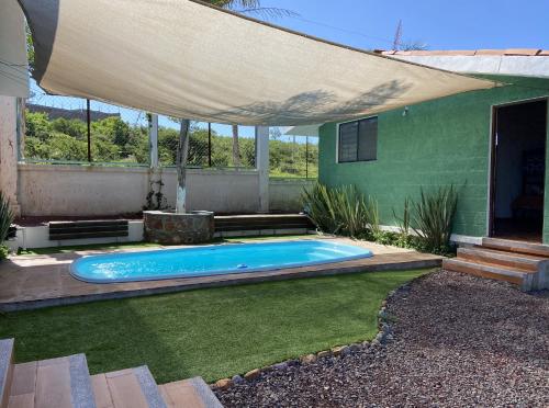 a swimming pool in a yard with a large umbrella at Tierra Linda in León