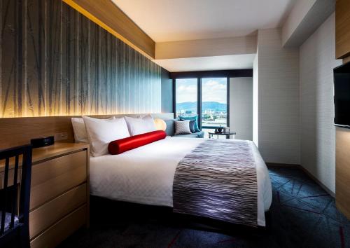 a hotel room with a bed with a red pillow at RIHGA Royal Hotel Kyoto in Kyoto