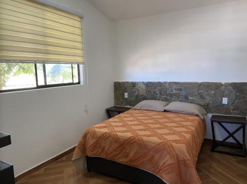 a bedroom with a bed and two windows at Tierra Linda in León