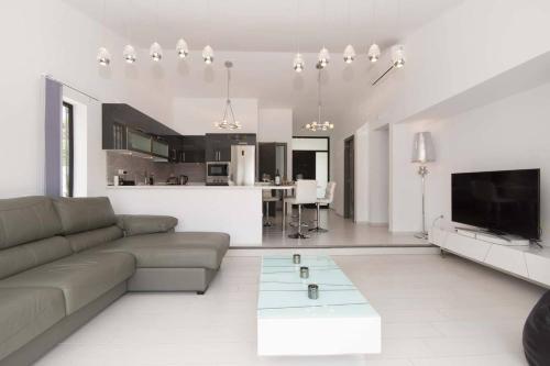 sala de estar con sofá y TV y cocina en Modern 3 Bedroom Villa Jaccuzi, en Playa Fañabe