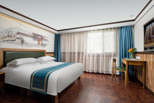 a hotel room with a large bed and a desk at Nost algia Hotel Near University of Technology -Shanxi museum 时光漫步酒店 太原理工大学下元店 Free fresh ground coffee,Free laundry service in Taiyuan