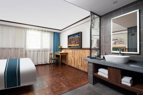 a bathroom with a bed and a sink and a mirror at Nost algia Hotel Near University of Technology -Shanxi museum 时光漫步酒店 太原理工大学下元店 Free fresh ground coffee,Free laundry service in Taiyuan