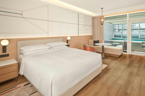 a bedroom with a white bed and a living room at The Link Seoul, a Tribute Portfolio Hotel in Seoul