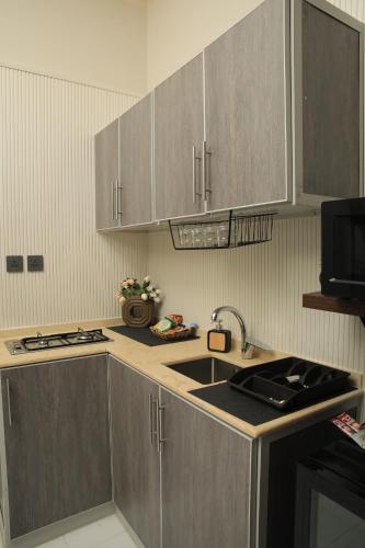a kitchen with stainless steel cabinets and a sink at The District in Jeddah