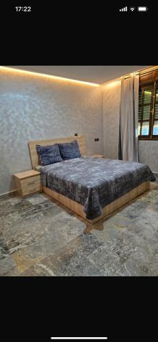 a bedroom with a large bed with blue pillows at Riad Targante Takate 2 in Takkat