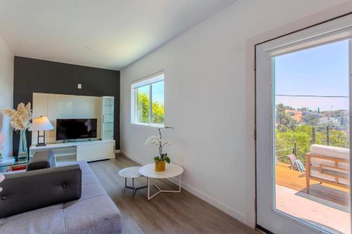 Una sala de estar con un sofá y una ventana grande. en Hillside Guest House with Sunset View, en Los Ángeles