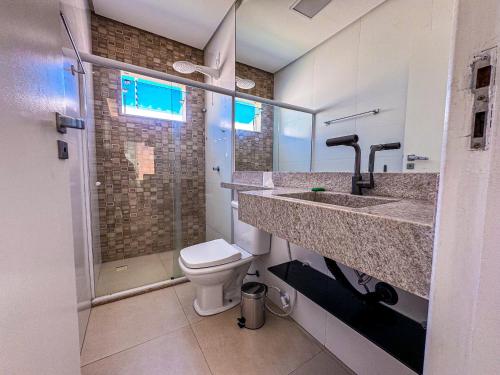 a bathroom with a toilet and a sink and a shower at Beach House Atalaia in Aracaju