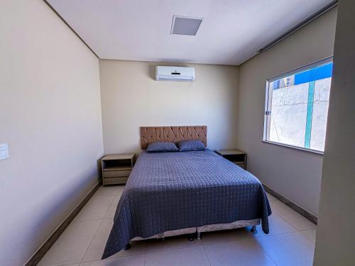 a bedroom with a bed and a window at Beach House Atalaia in Aracaju