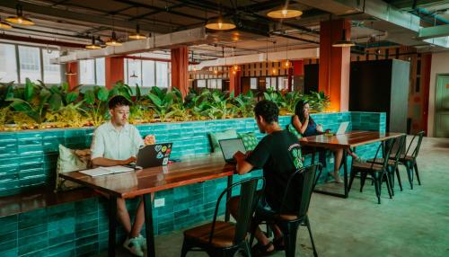 a group of people sitting at tables in a restaurant at Viajero Casco Viejo Hostel in Panama City