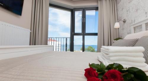 a bedroom with a bed with a view of the ocean at Horyzont Luksusowe apartamenty nad morzem z parkingiem Międzyzdroje in Międzyzdroje
