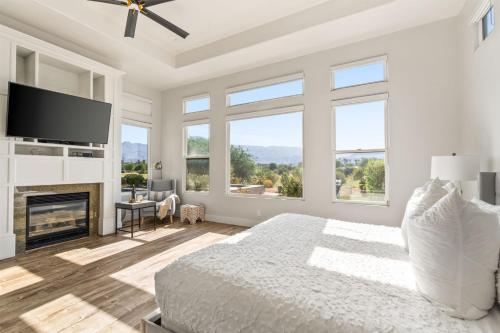 a white bedroom with a bed and a fireplace at Multi-Million Dollar PGA West 4BR 5BA Pool Spa in La Quinta