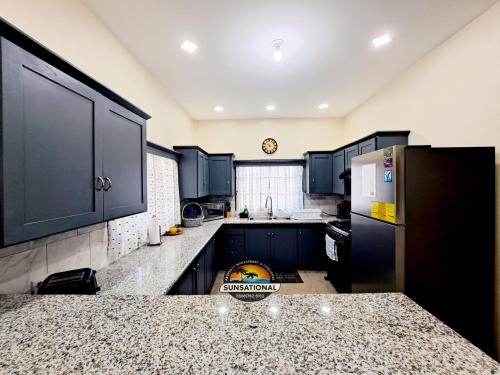a kitchen with black cabinets and a counter top at Sugar Haven Villas in Crown Point