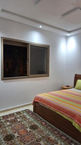 a bedroom with a bed and a window at Chambres au sein d'une villa in Rabat