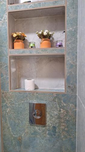 a shelf with flowers and vases on it at Chambres au sein d'une villa in Rabat
