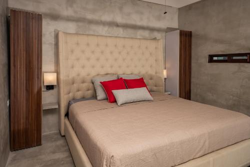 a bedroom with a large bed with two red pillows at Loft de lujo en excelente ubicación in Cancún