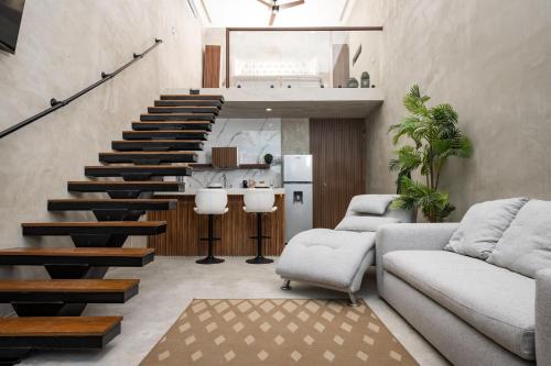 a living room with a staircase with a couch and chairs at Loft de lujo en excelente ubicación in Cancún