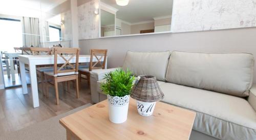 a living room with a couch and a table at Horyzont Luksusowe apartamenty nad morzem z parkingiem Międzyzdroje in Międzyzdroje