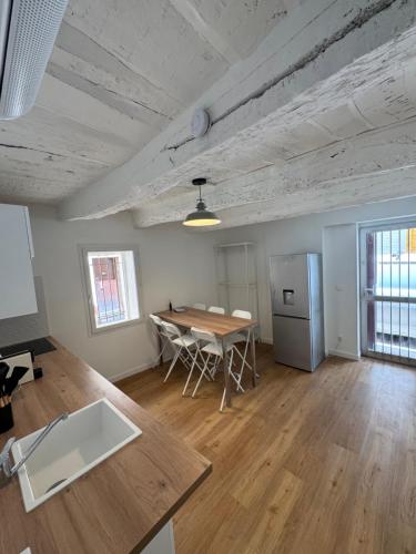 a living room with a table and a refrigerator at Marceau II - Une pépite dans le cœur de ville in Aubagne