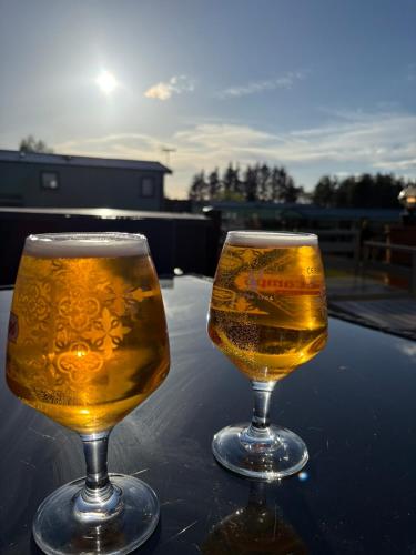 two glasses of beer sitting on top of a table at Slaley Forest Hexham Caravan Retreat Pet Friendly - sleeps 6 in Slaley