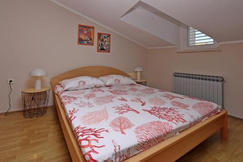 a bedroom with a bed with a red and white blanket at Apartments and rooms with parking space Vrbnik, Krk - 5302 in Vrbnik