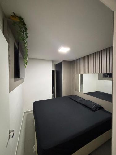 a bedroom with a black bed in a room at Luxury Studio Ubatuba in Ubatuba