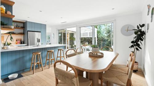 a kitchen and dining room with a wooden table and chairs at The Salty Perch in Callala Beach