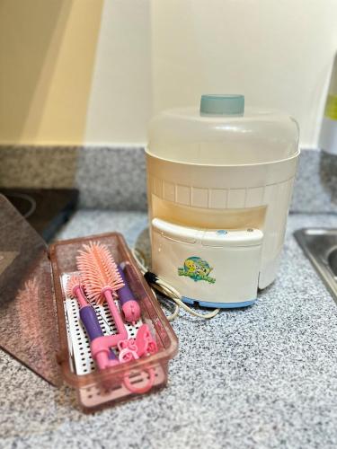 a container of utensils sitting on a counter next to a mixer at SplashNStay in Puting Kahoy