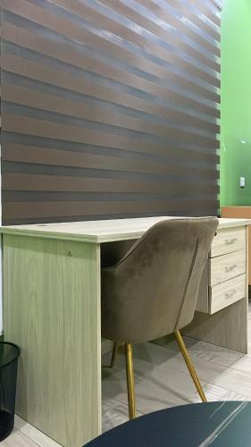 a desk with a chair in a room at Serene Suites 1 King Bedroom in Otinshi