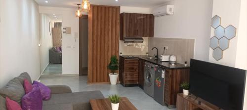 a kitchen and a living room with a couch and a stove at Modern Studio in Kenitra Center Netflix & IPTV in Kenitra